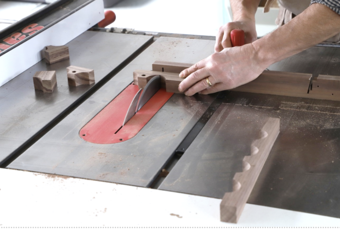 Tom cuts the ripped boards into small sections, using a miter gauge at the table saw.